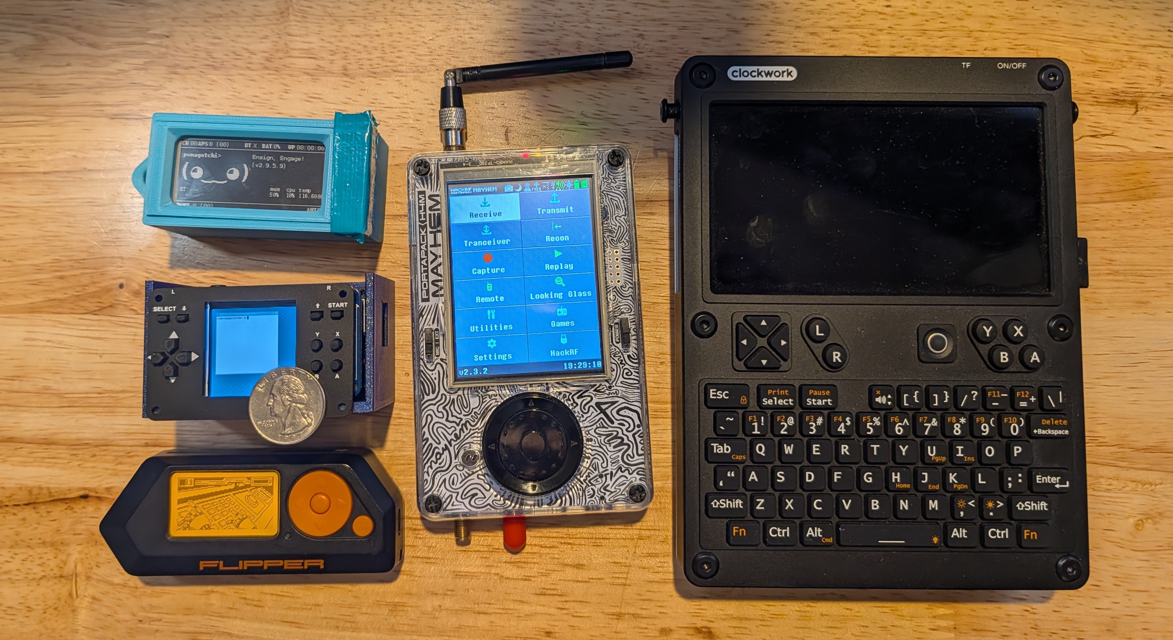 Current travel kit with pwnagotchi, Flipper Zero, new micro-cyberdeck (with quarter for size comparison), HackRF Portapack H4M, and uConsole
